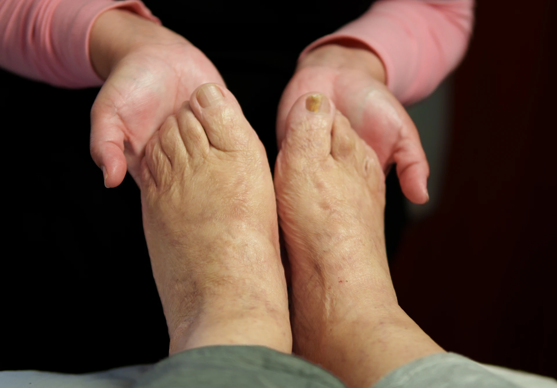 Hands massaging elderly feet